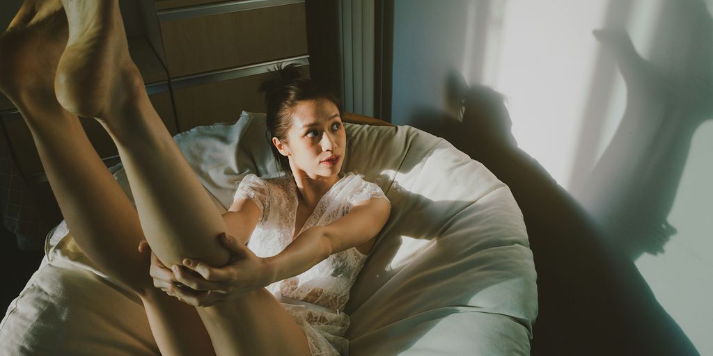 a woman laying in bed with her legs spread out