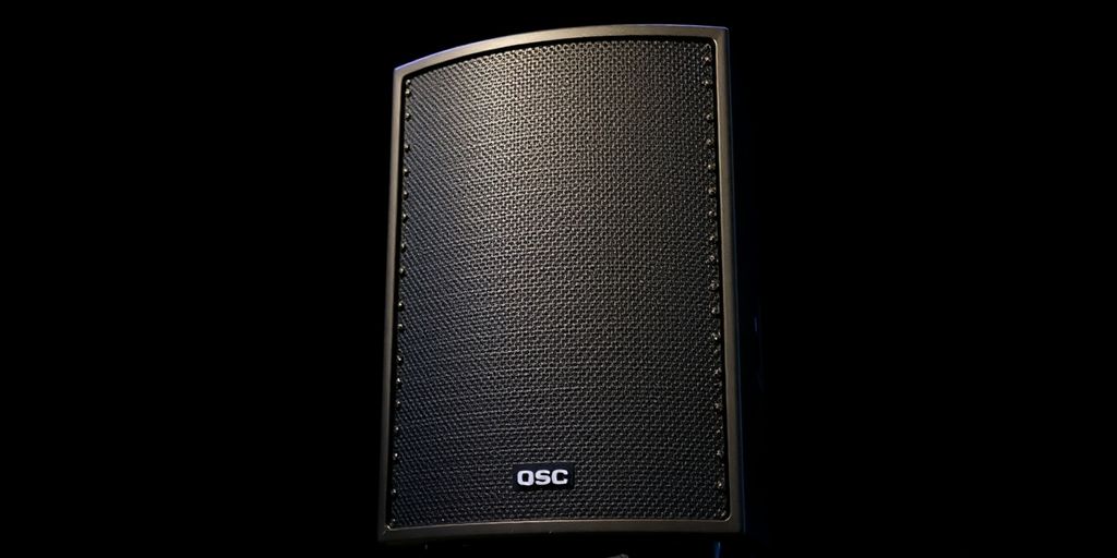 QSC K8.2 powered speaker on a stage.