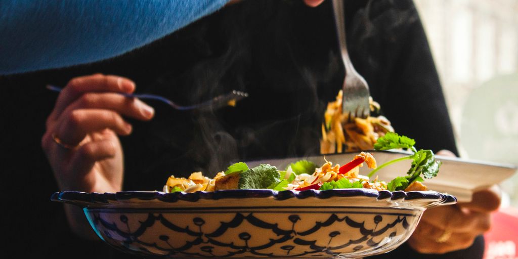 selective focus photography of person holding fork picking on cooked food