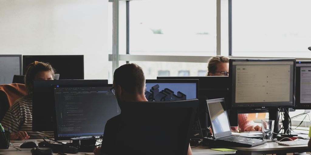 Personen, die vor dem Computermonitor auf Stuhl sitzen