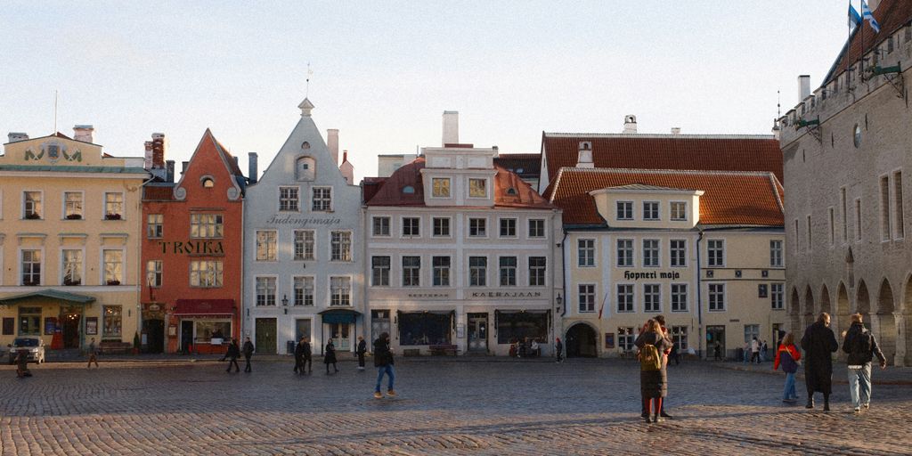 A group of people walking around a cobblestone street