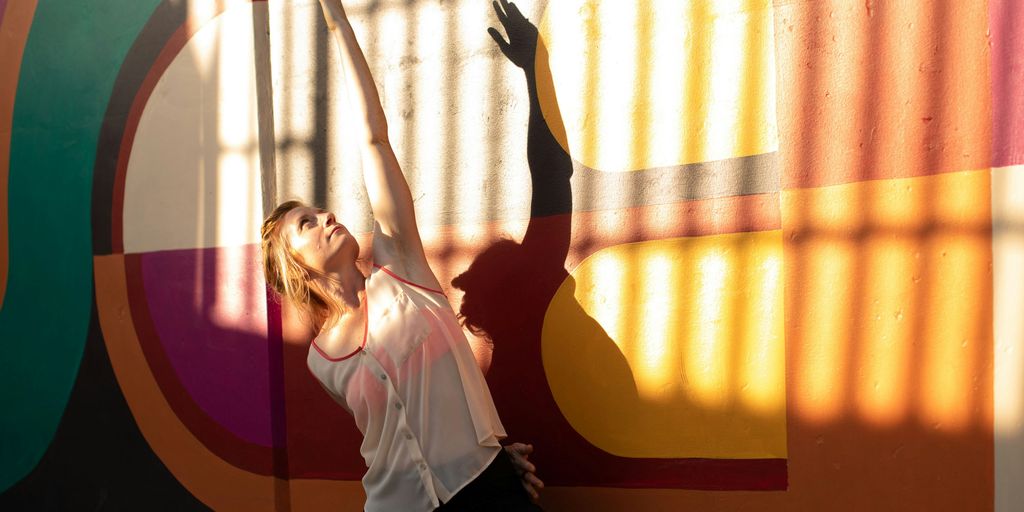 a person standing in front of a colorful wall