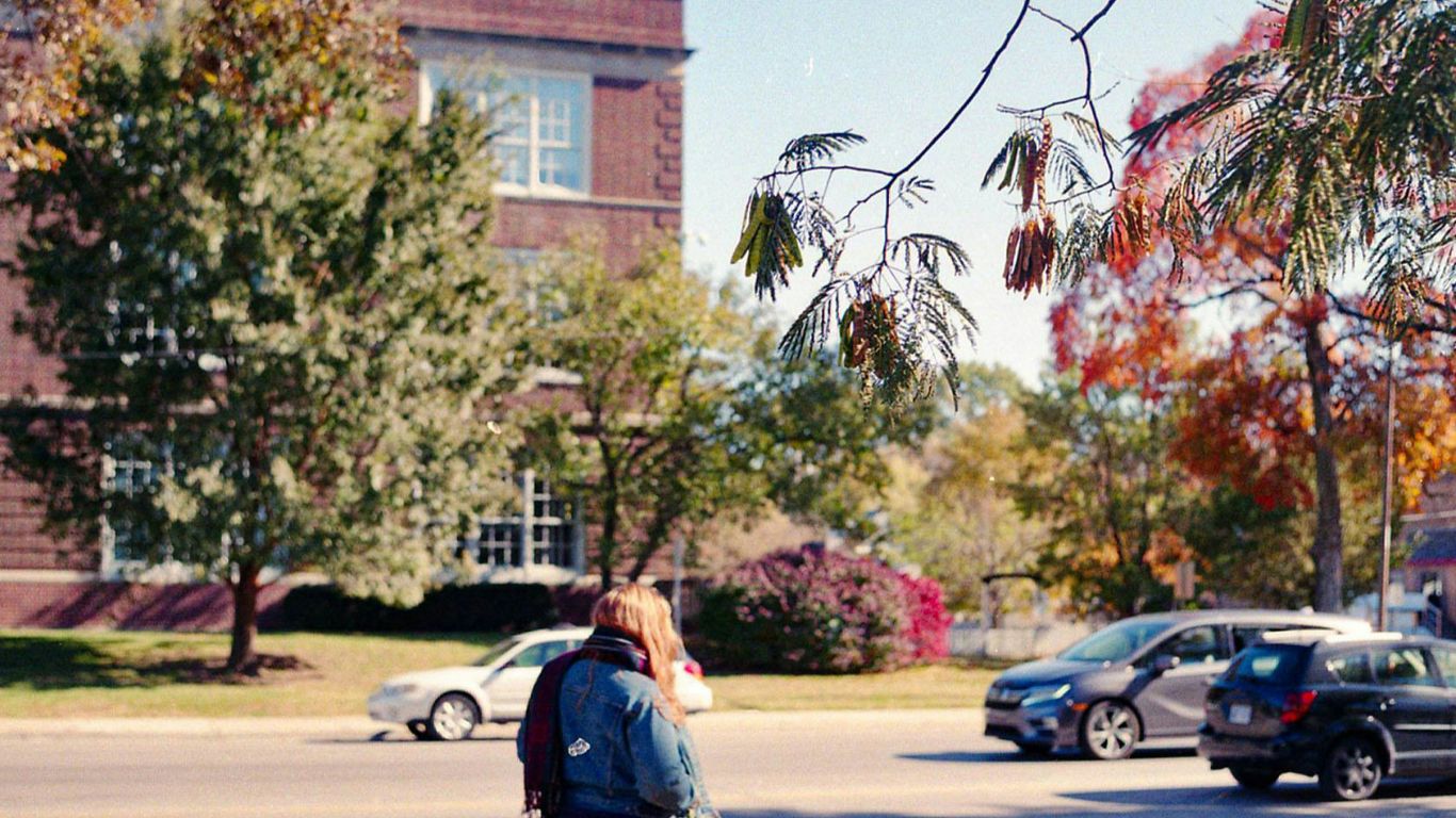 a woman walking down a street while holding a frisbee