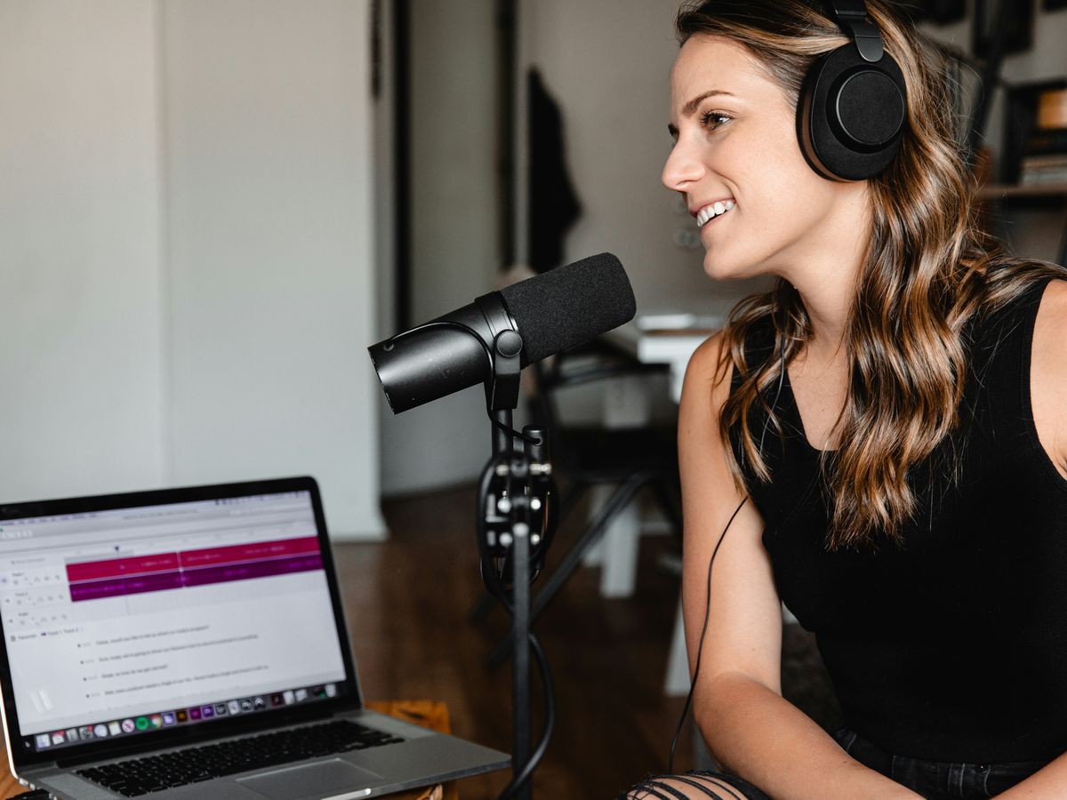 woman in black tank top sitting on chair in front of microphone