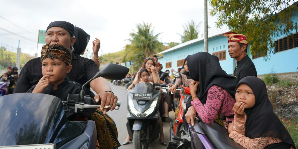 A group of people riding motorcycles down a street