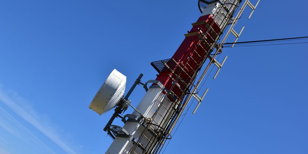 a cell phone tower with a lot of antennas on top of it