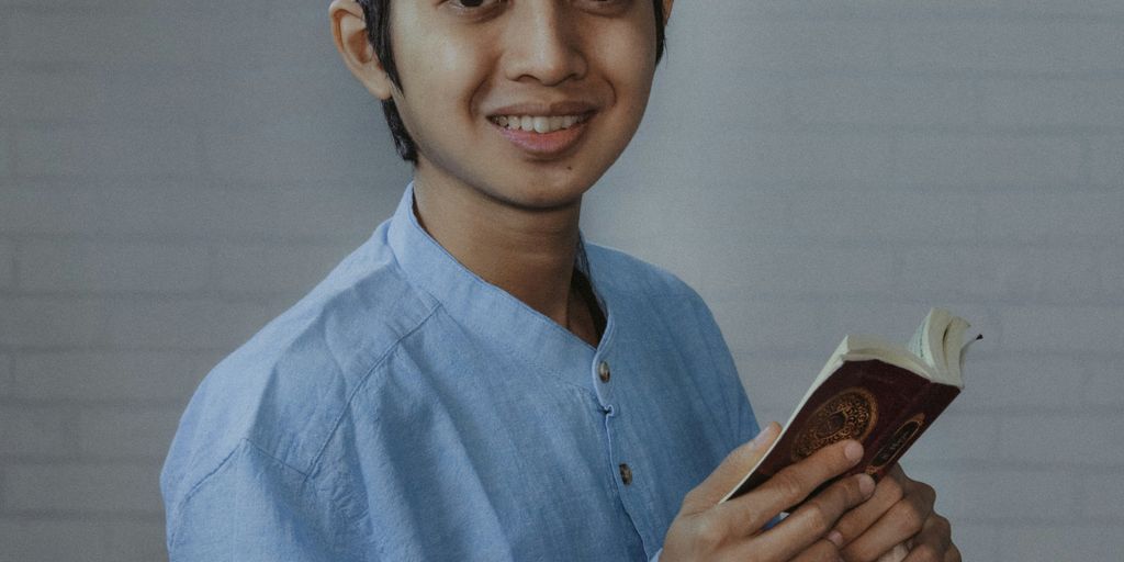 man in blue dress shirt holding brown smartphone