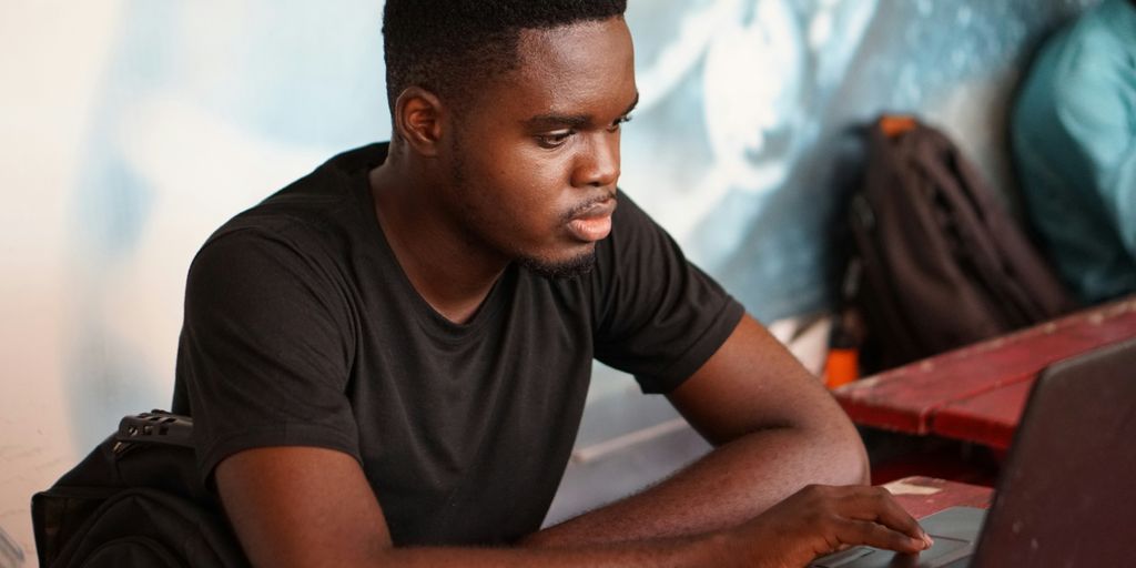 man in gray crew neck t-shirt using laptop computer