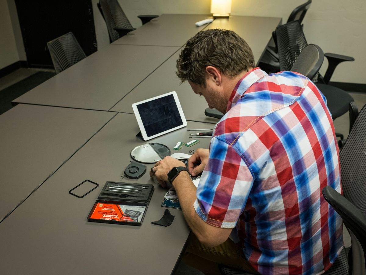 man sitting on chair and writing on desk