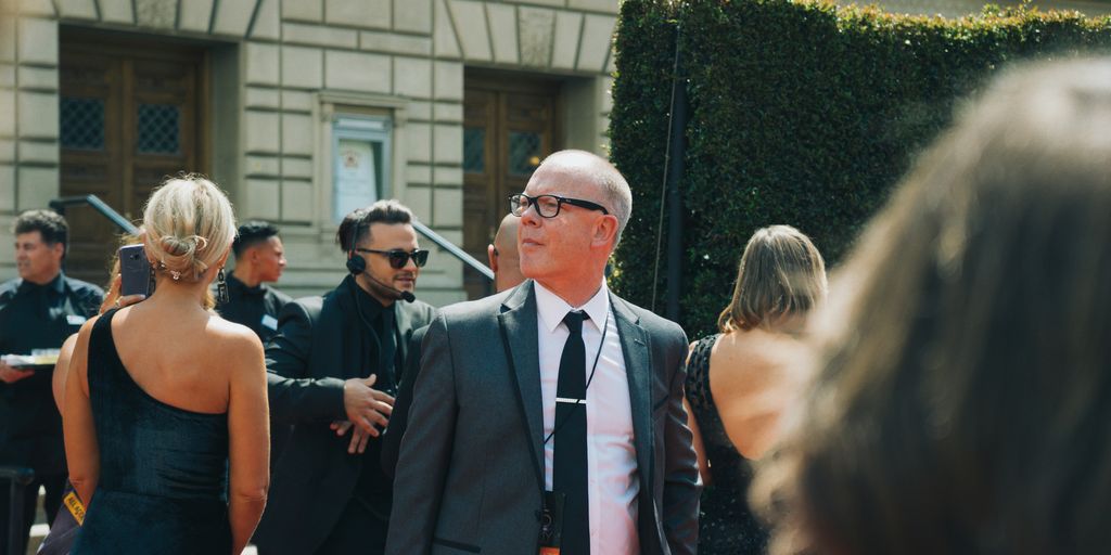 man in black suit standing beside woman in black sleeveless dress