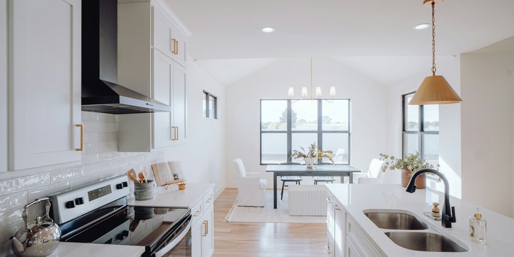 a kitchen with a sink, stove, and a window