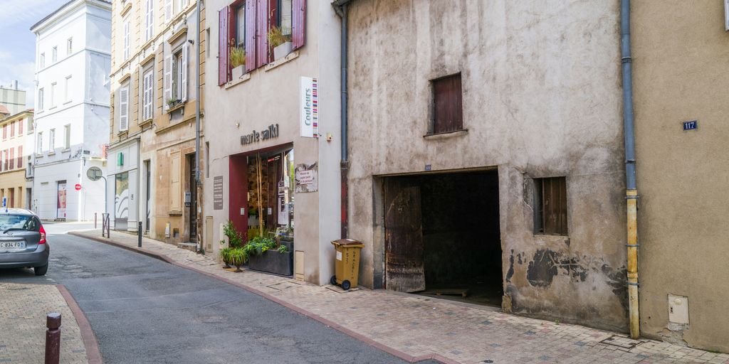 a car parked on the side of a street next to a building