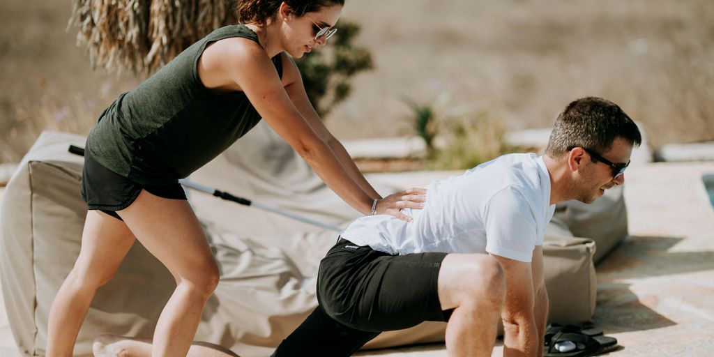 a man and a woman doing yoga outside