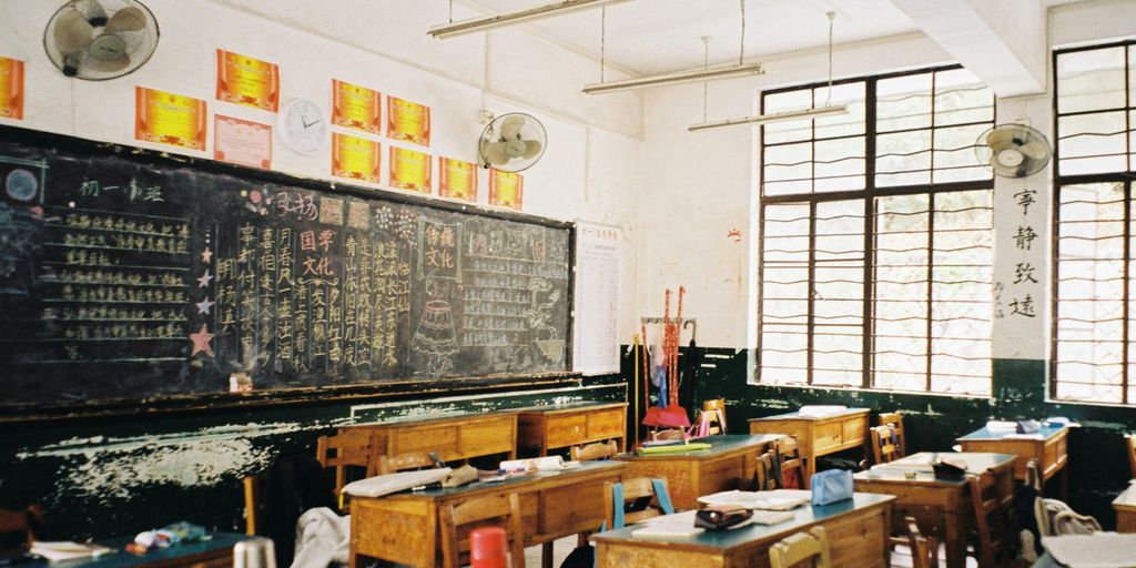 a classroom filled with desks and a chalkboard