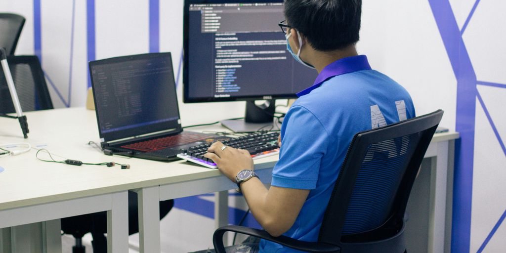 boy in blue t-shirt sitting on black office rolling chair in front of computer