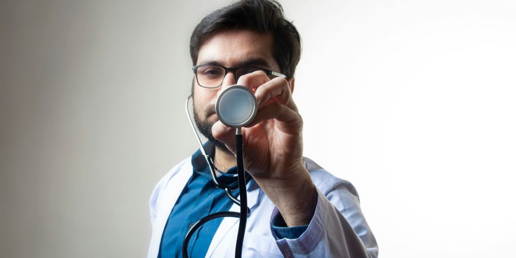 person in white shirt holding black and silver headphones