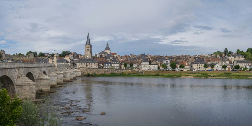 a bridge over a river with a city in the background