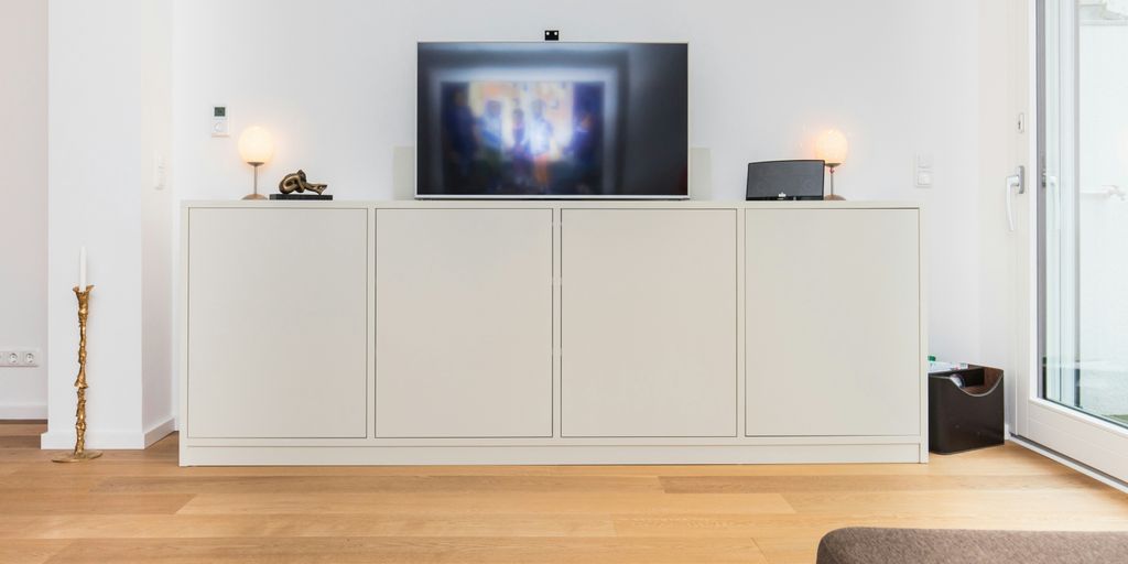 black flat screen tv turned on on white wooden tv hutch