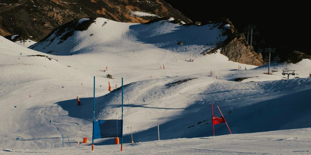 a snow covered ski slope with a mountain in the background