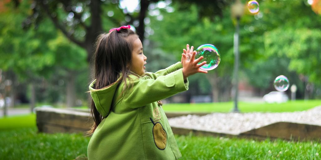 selective photo of a girl holding bubbles