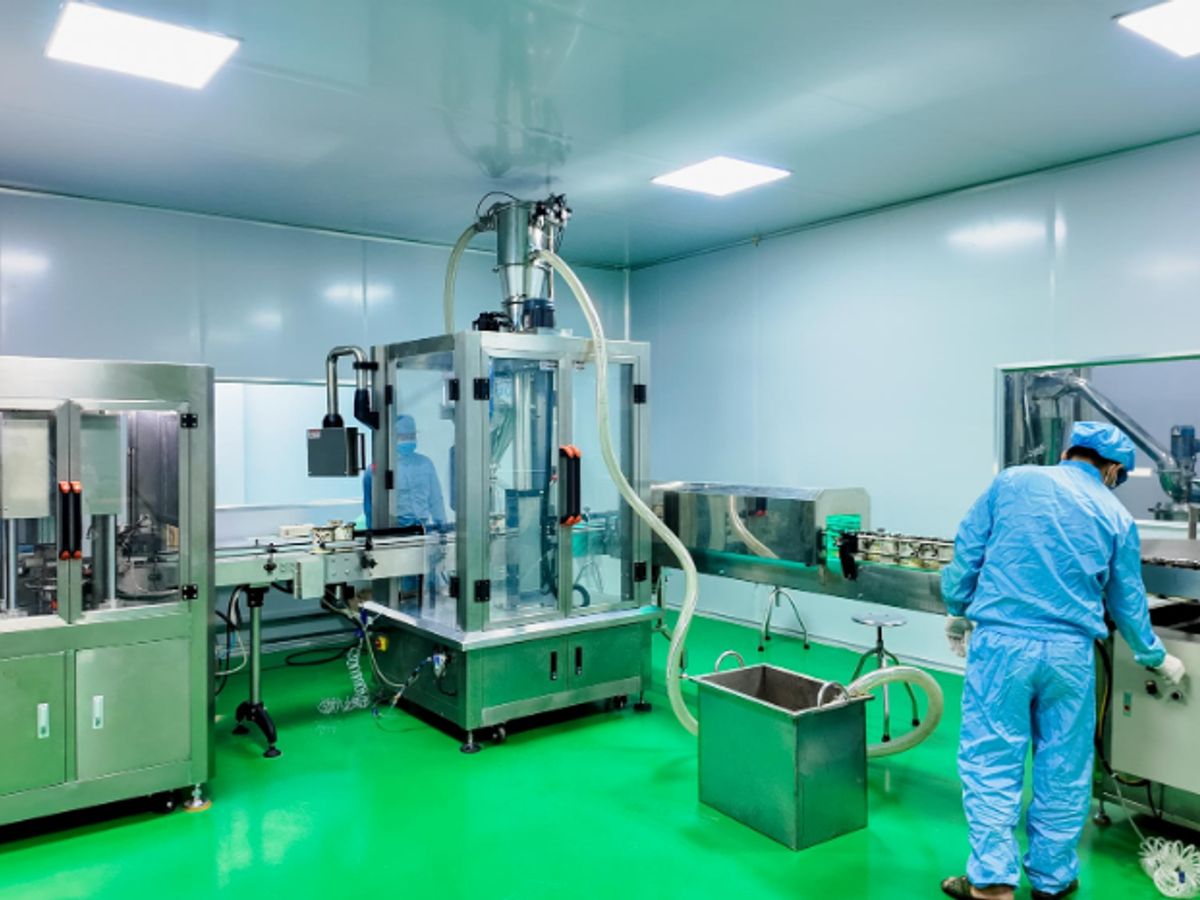 Clean room environment with machinery and personnel in protective gear.