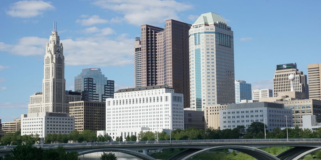 a bridge over a river with a city in the background