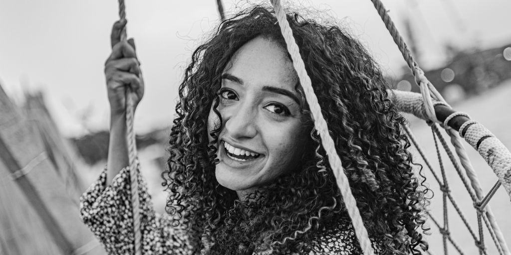 a woman smiling while sitting on a boat