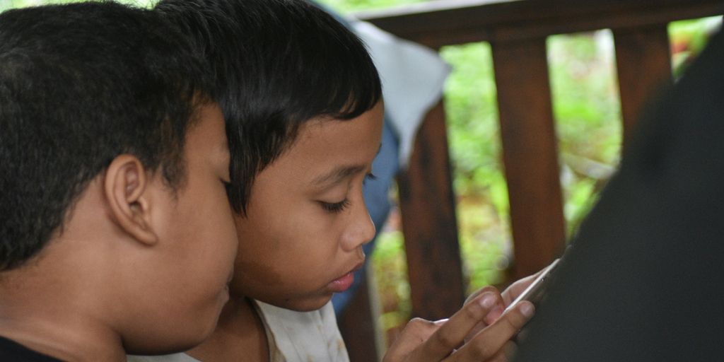 boy in white shirt holding black textile