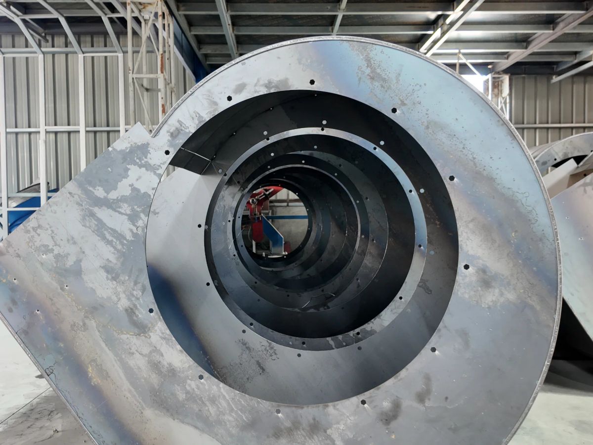 Metal spiral structure in an industrial setting with circular openings.