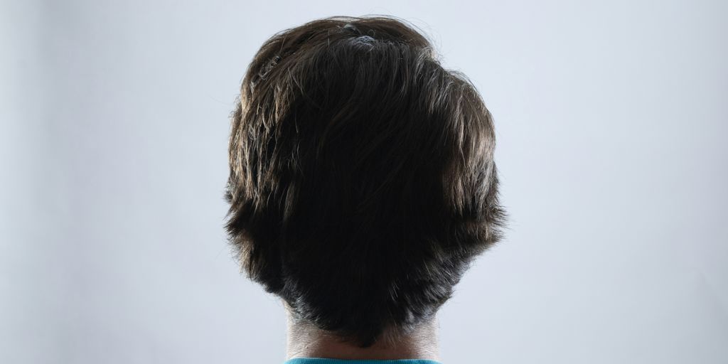 The back of a man's head in a blue shirt