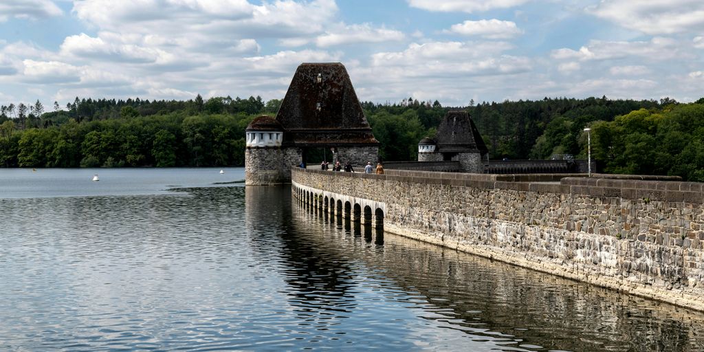 a large body of water next to a stone wall