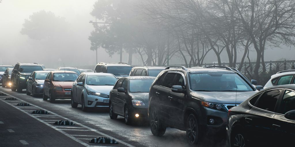 Cars are in a traffic jam on a foggy day.