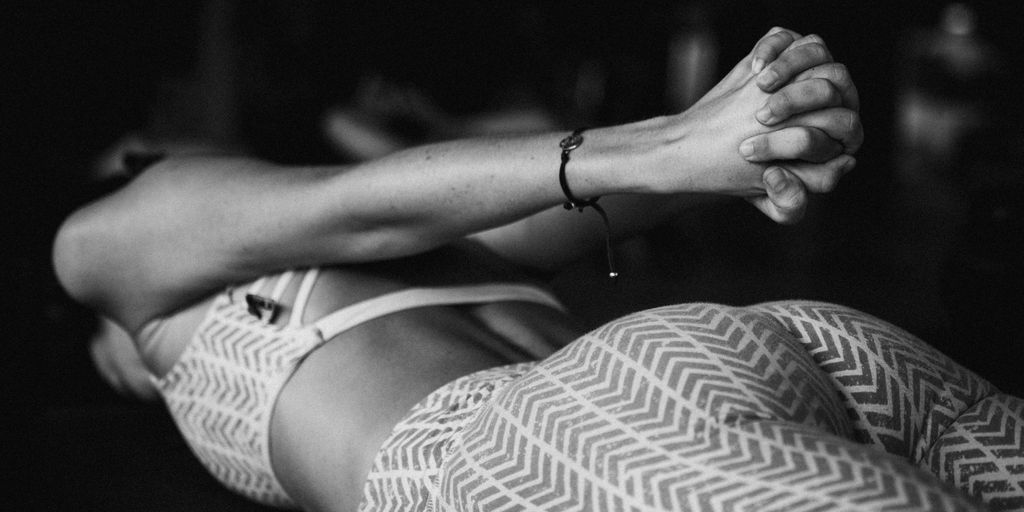 a black and white photo of a woman laying on the ground