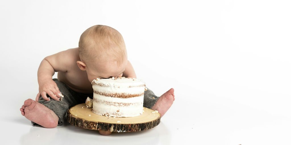 kid sitting beside round cake close-up photography