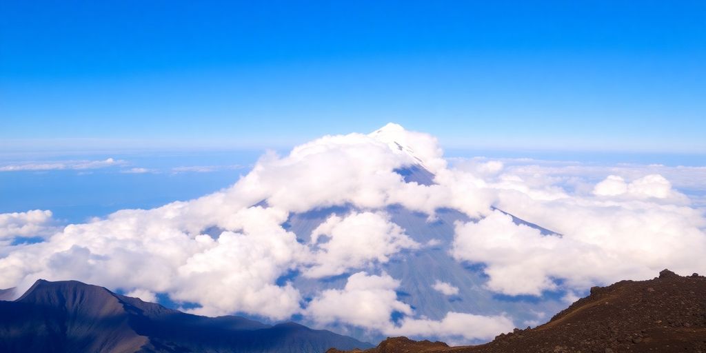 Mount Rinjani summit view with clouds below.