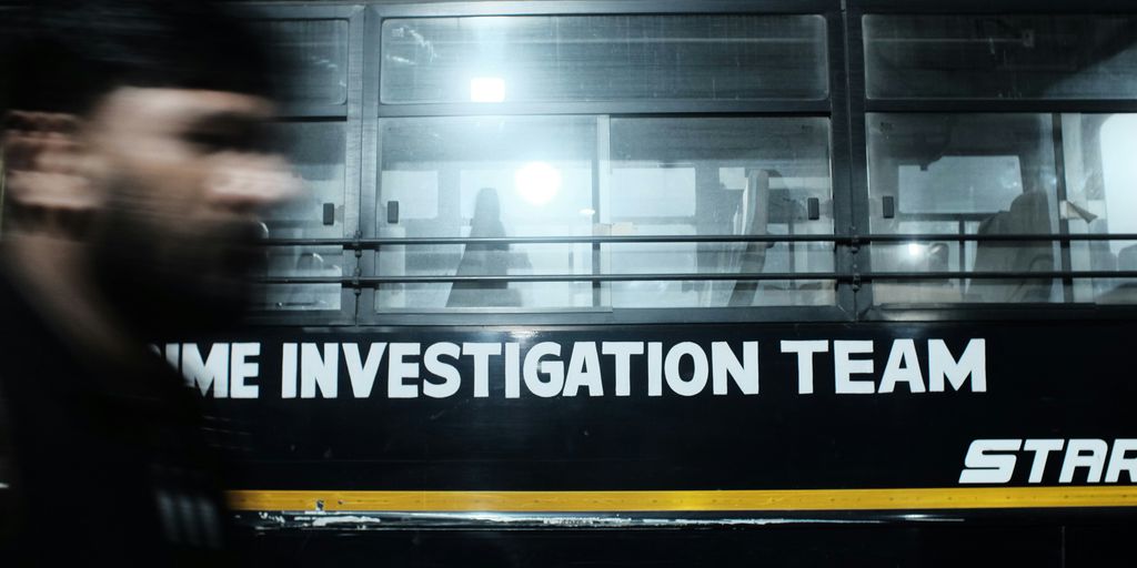 A blurry photo of a man walking in front of a bus