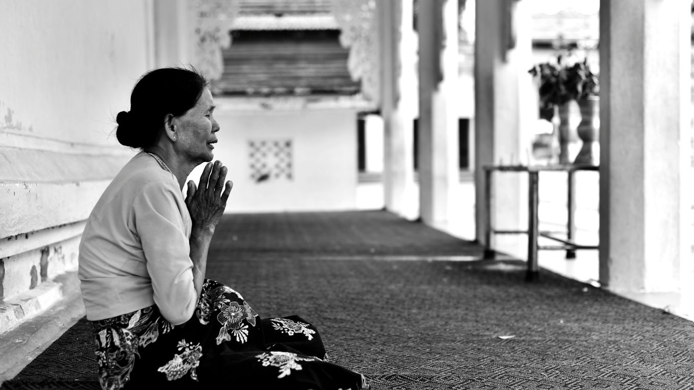 woman praying in grayscale photo
