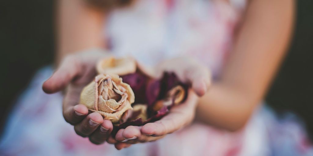 selective focus photography of a girl holding flowers