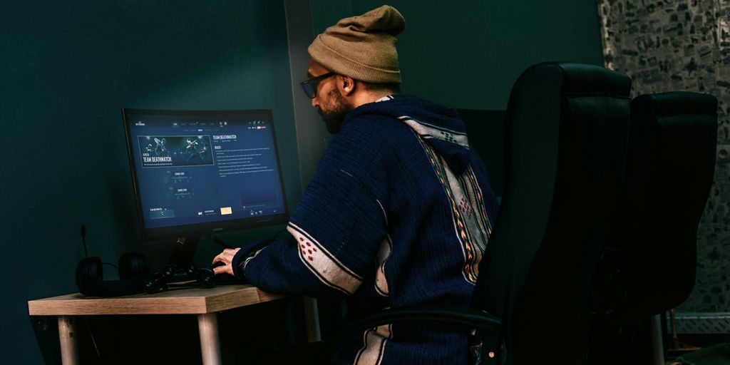 a man sitting in front of a computer monitor
