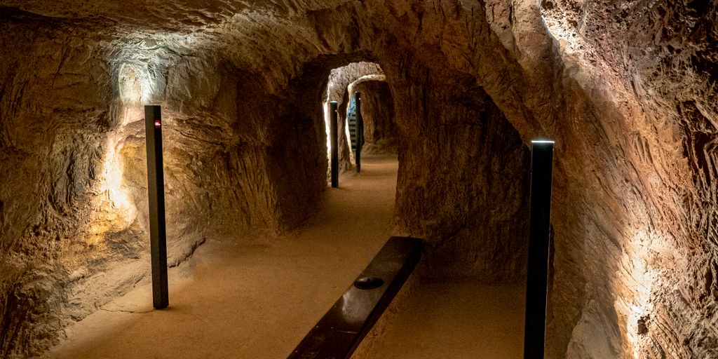 a long narrow tunnel with a bench in the middle of it
