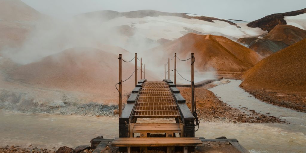 a wooden bridge over a stream of water
