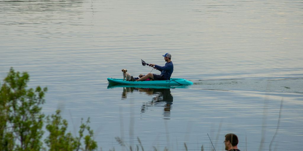 man and woman riding on blue kayak on lake during daytime