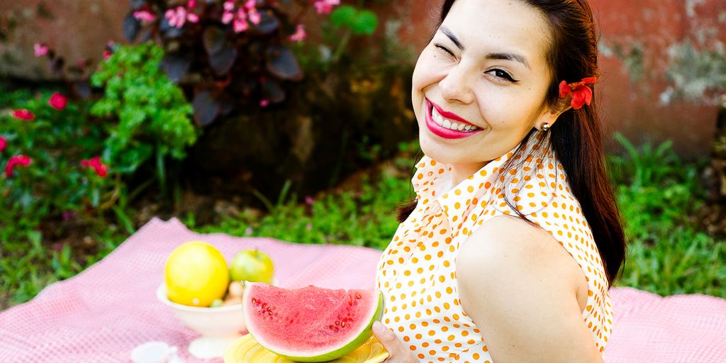 woman holding plate of sliced watermelon