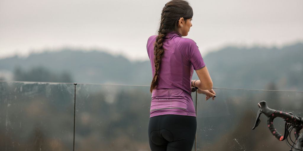 woman in pink shirt and black shorts running on road during daytime