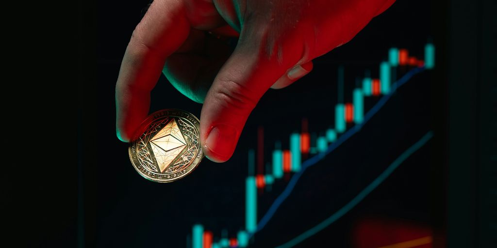 Hand holds ethereum coin over the stock chart.