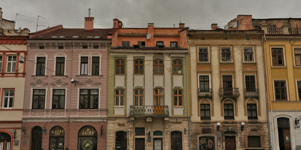 brown and white concrete building under white clouds during daytime