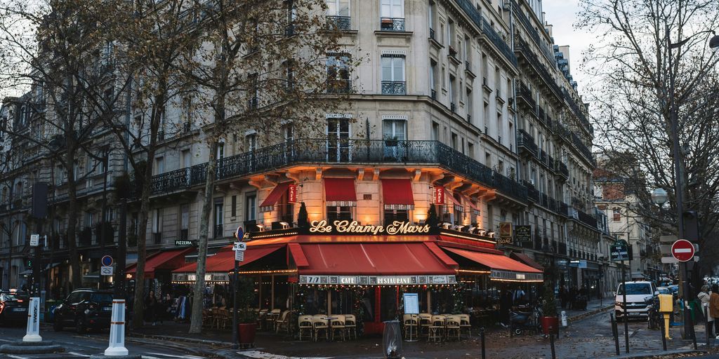 a building with a red awning in the middle of a street