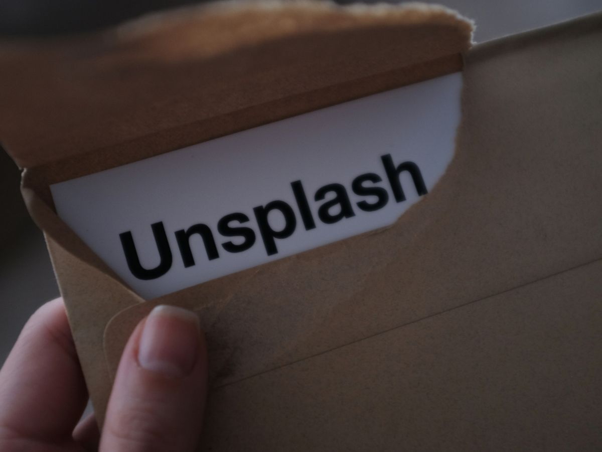 closeup photo of person holding brown envelope