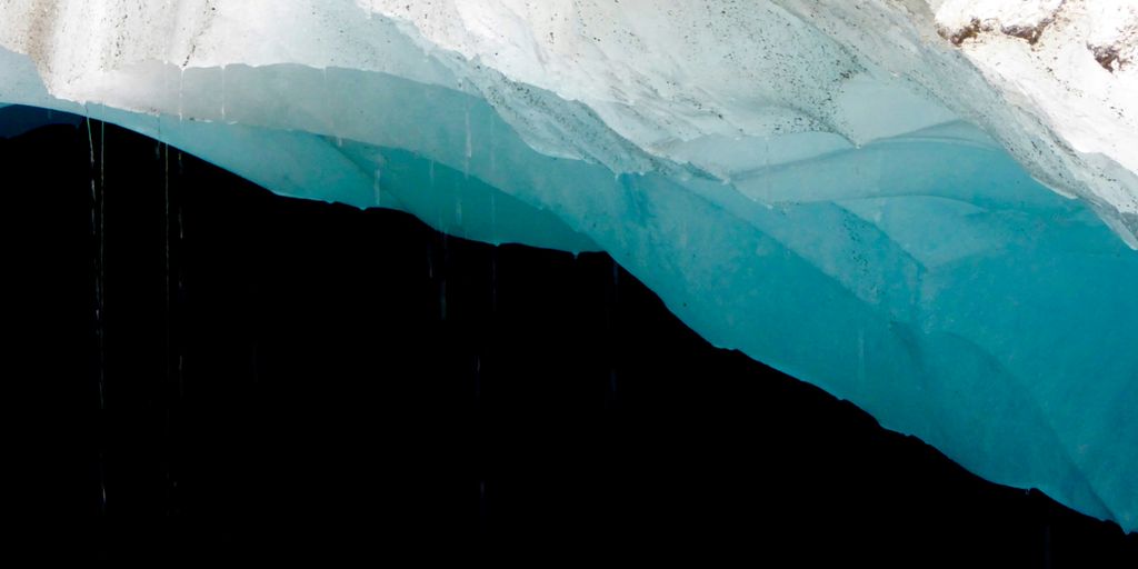 a large iceberg with a blue water below it