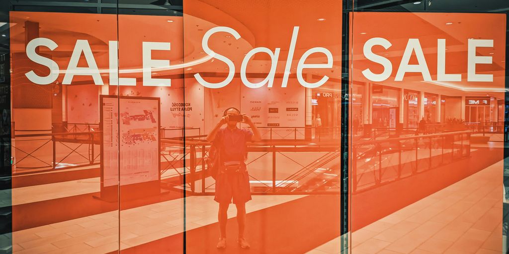 A store window with a sale sign on it
